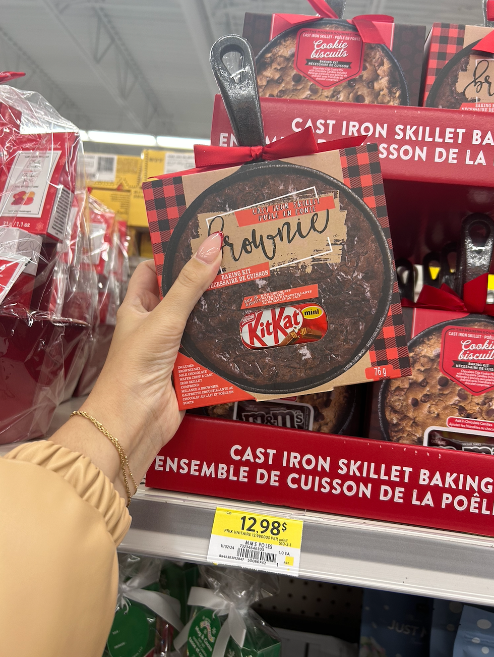 Une main tenant un ensemble de cuisson de brownie au Kit Kat avec po\u00eale en fonte au Walmart.
