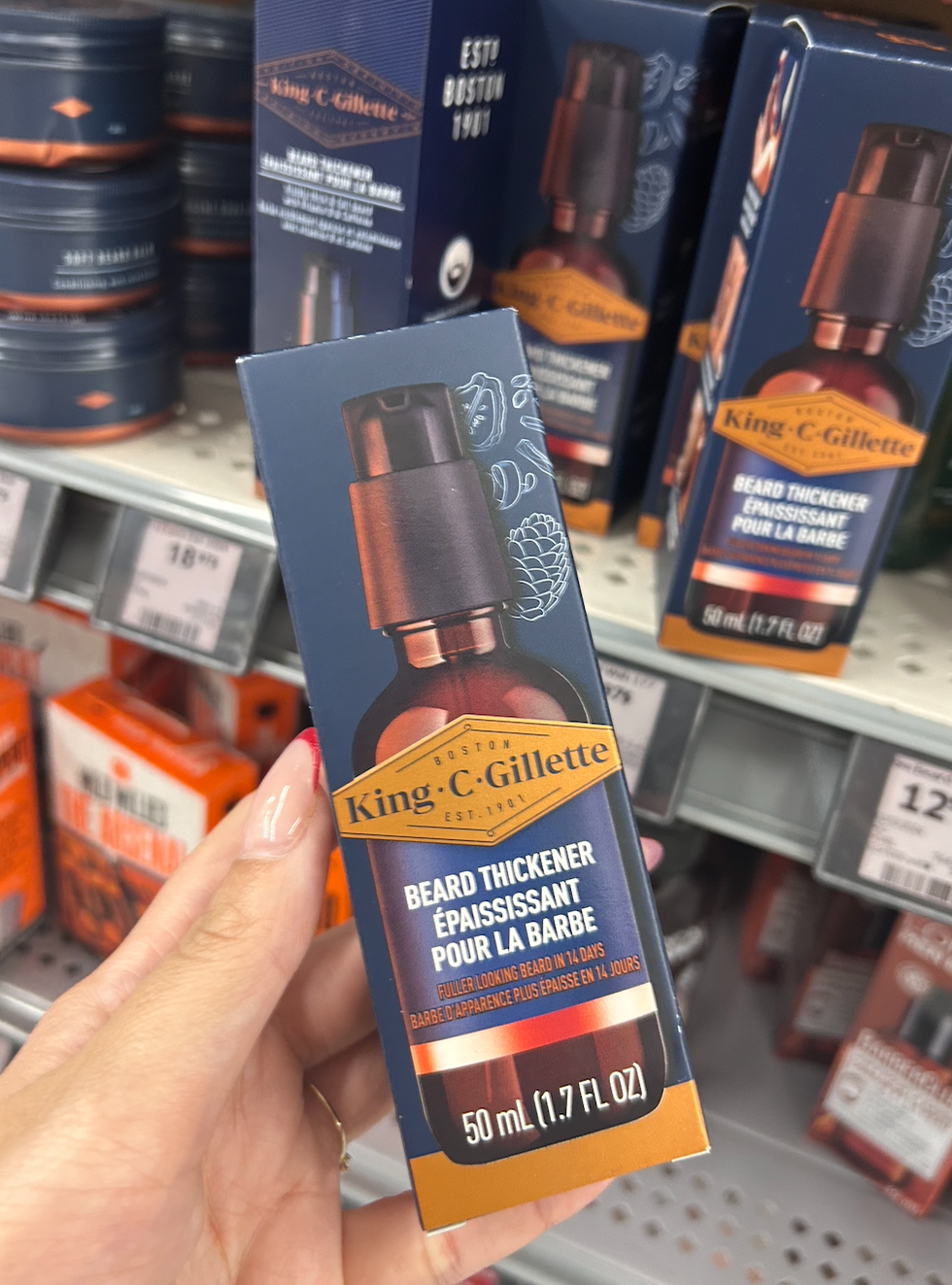 Une main tenant un \u00e9paississant pour la barbe de la marque King C. Gillette.