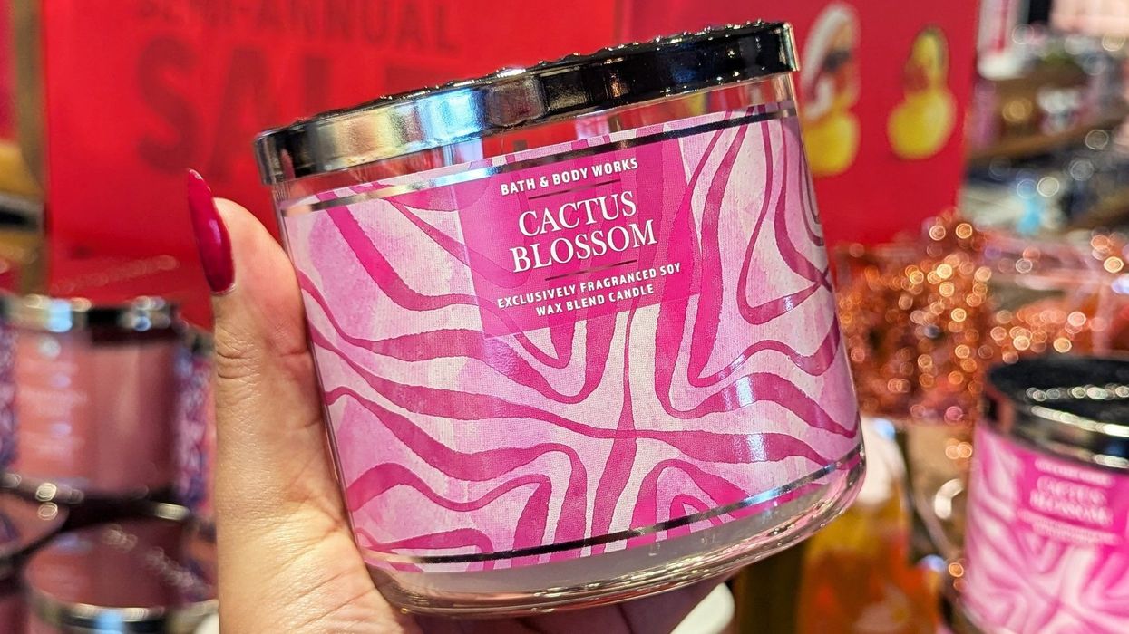 Une main tenant une chandelles trois mèches au Bath & Body Works.