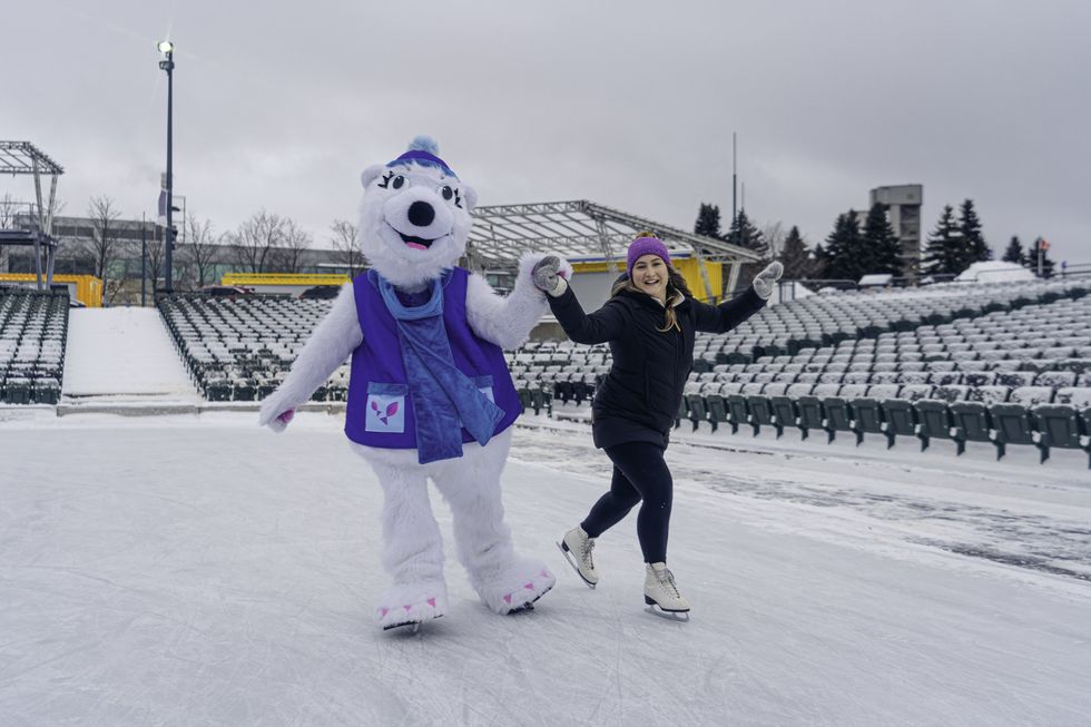 Une mascotte et une personne sur la Discoglace du Port de Qu\u00e9bec durant le jour.