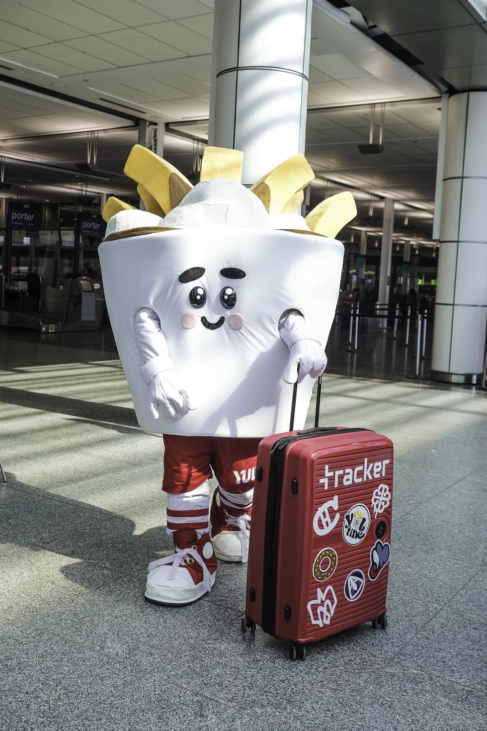 Une mascotte prend la pose avec sa valise \u00e0 l'a\u00e9roport de Montr\u00e9al.