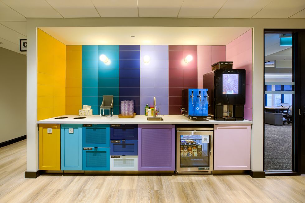 Une micro-cuisine color\u00e9e avec une machine \u00e0 caf\u00e9, une distributrice de boissons gazeuses et un mini-frigo.