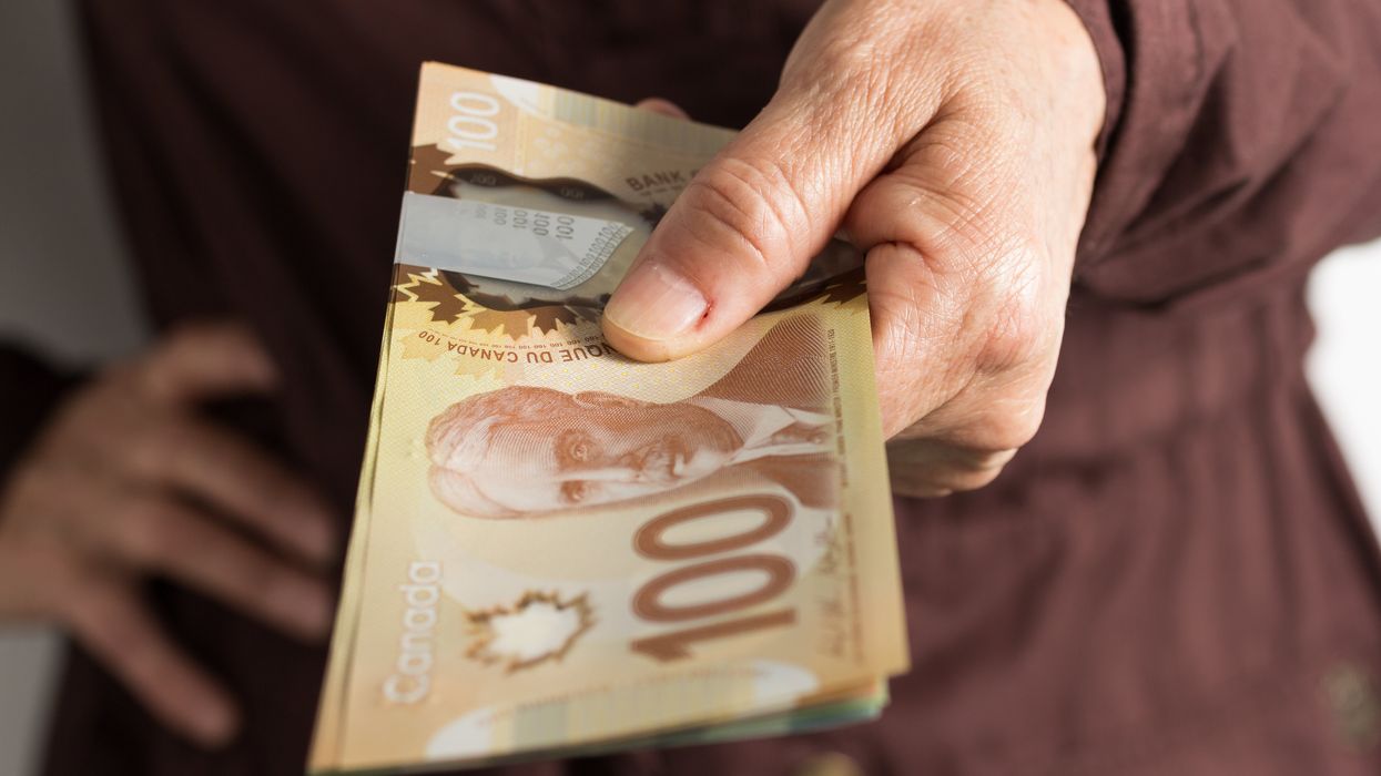 Une personne âgée qui tient de l'argent canadien.