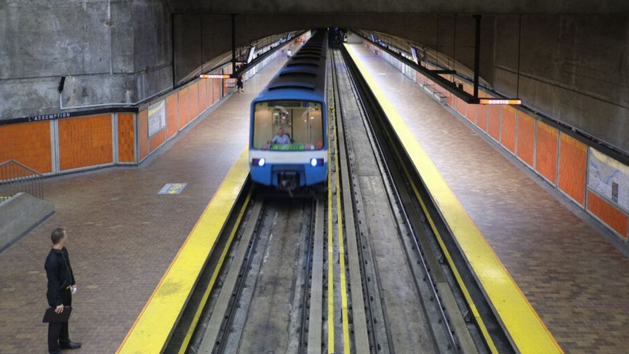 Une personne attend le métro qui s'approche dans une station à Montréal.