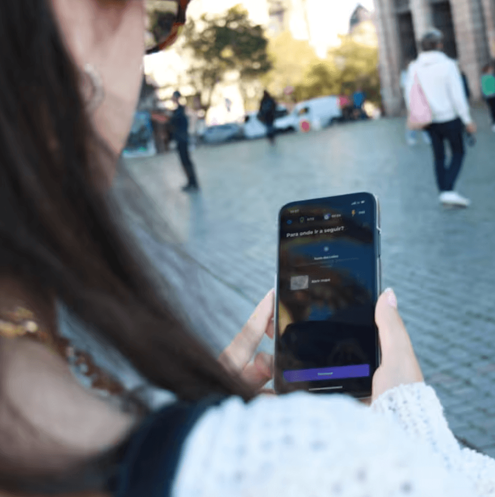 Une personne de dos avec ton t\u00e9l\u00e9phone intelligent \u00e0 la main.