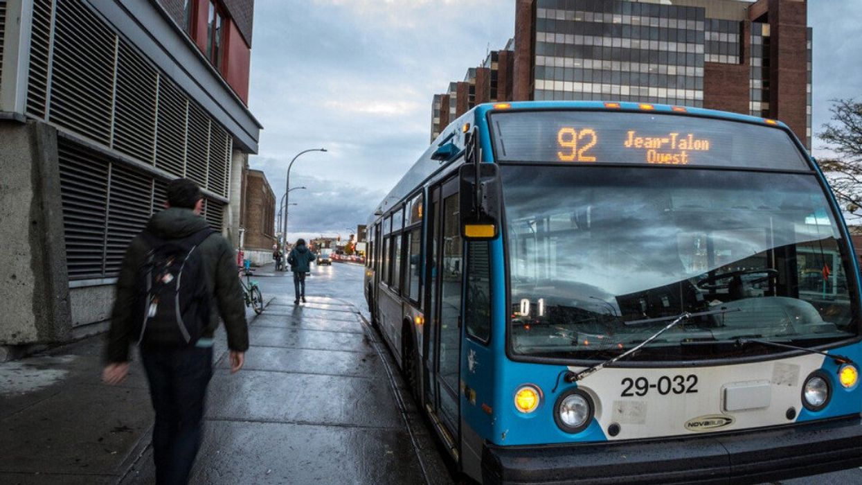 Une personne marche à côté d'un autobus à Montréal.
