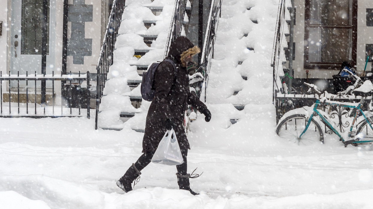 Une personne marche dans une rue enneigée à Montréal.