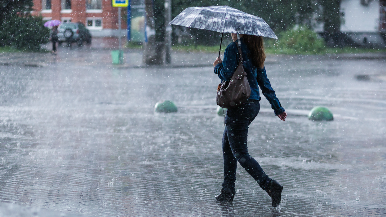 Une personne marche sous la pluie avec son parapluie.