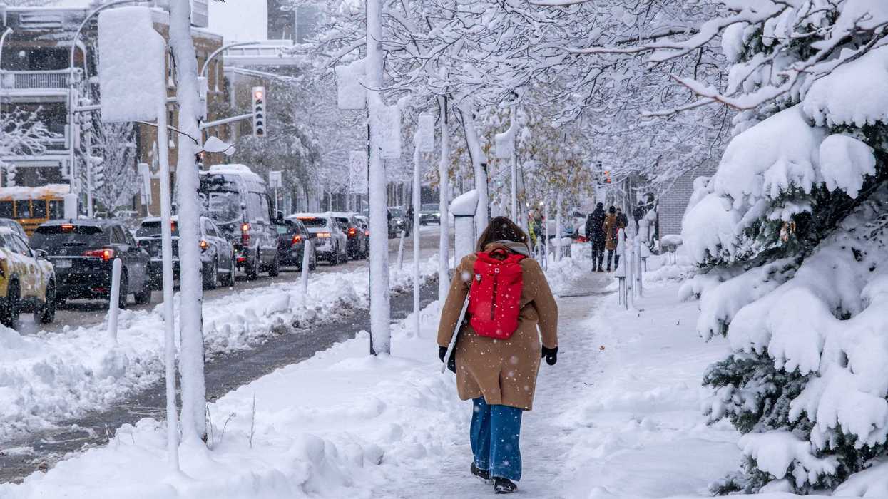 Une personne qui marche dans la rue lors d'une tempête de neige à Montréal.