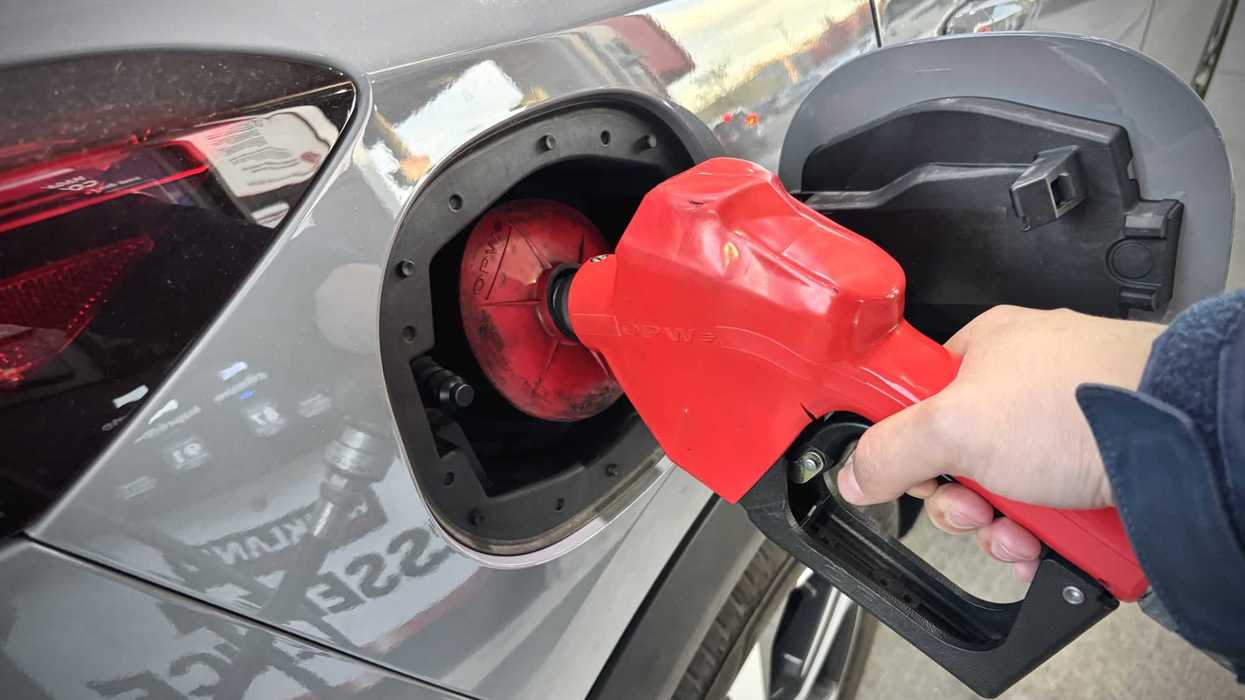 Une personne qui met de l'essence dans une voiture.