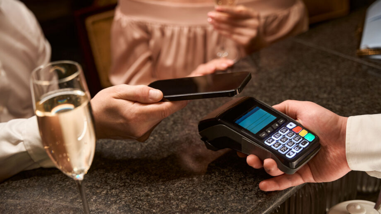 Une personne qui paye à un terminal bancaire.