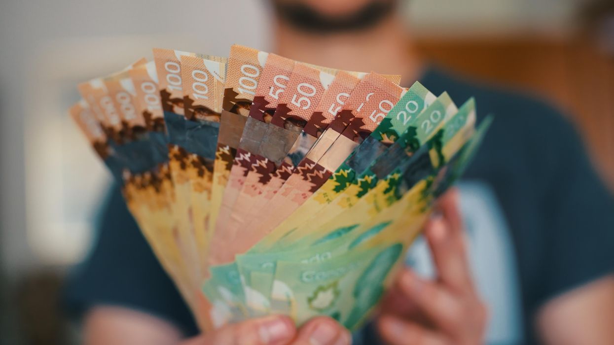 Une personne qui tient de l'argent canadien dans ses mains.