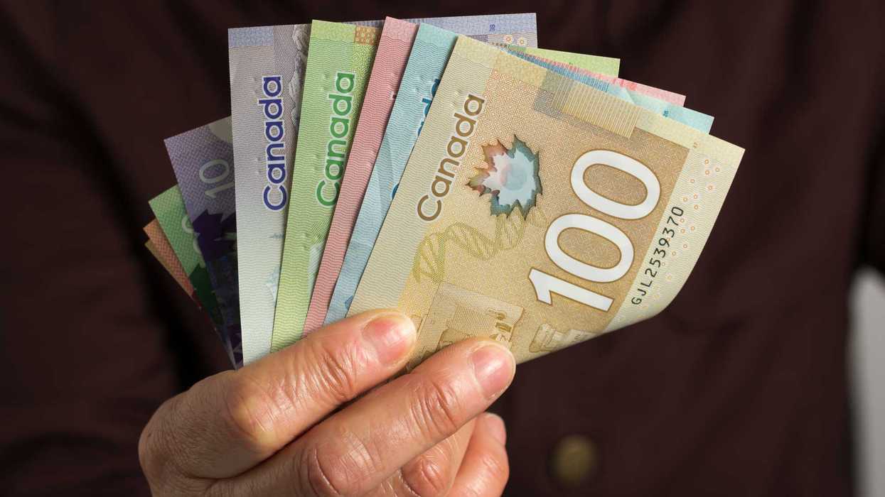Une personne qui tient de l’argent canadien.