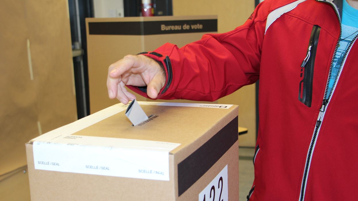 Une personne qui vote à un bureau de scrutin.