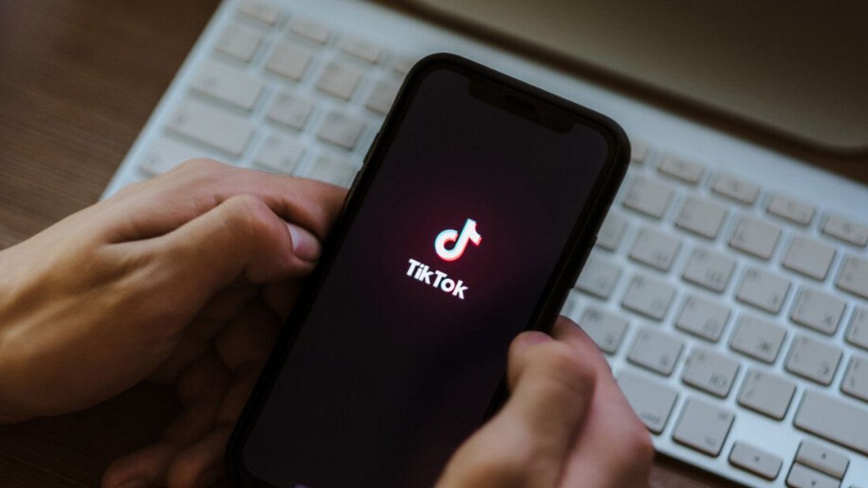 Une personne tenant son téléphone avec l'application TikTok.