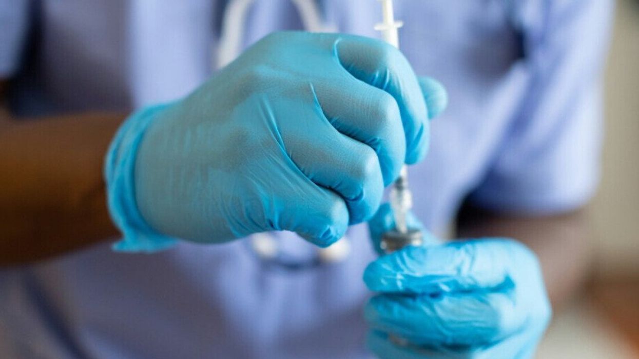 Une personne tenant un flacon d'injection.