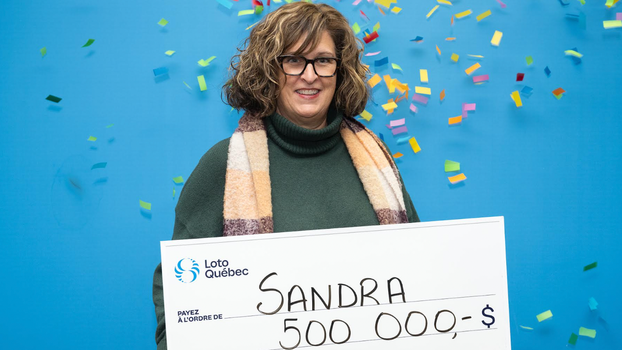 Une personne tient un grand chèque de Loto-Québec de 500 000 $ entre ses mains.