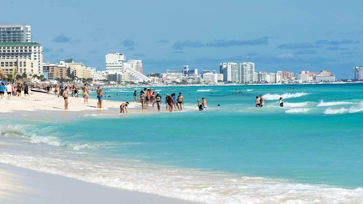 Une plage à Cancùn avec des personnes en train de se baigner.