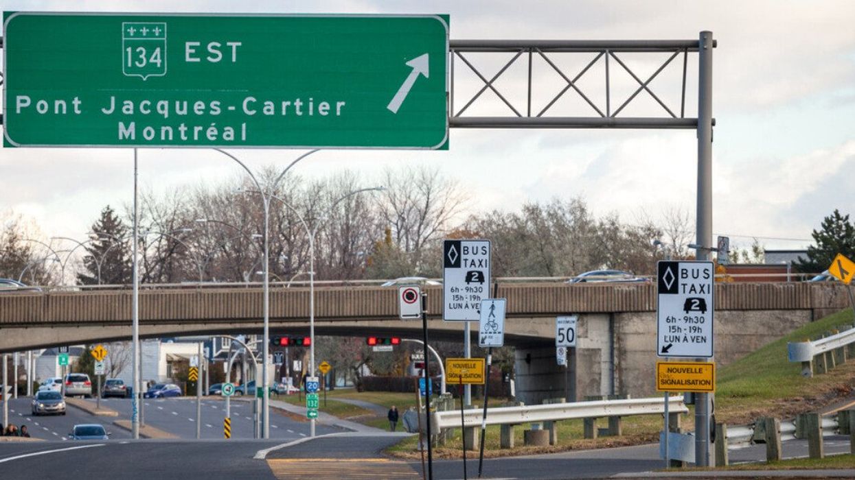 Une route avec une affiche verte où il est écrit « Pont Jacques-Cartier Montréal ».