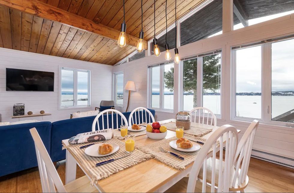 Une table pr\u00e9par\u00e9e pour un repas dans une salle \u00e0 manger avec vue sur le fleuve.