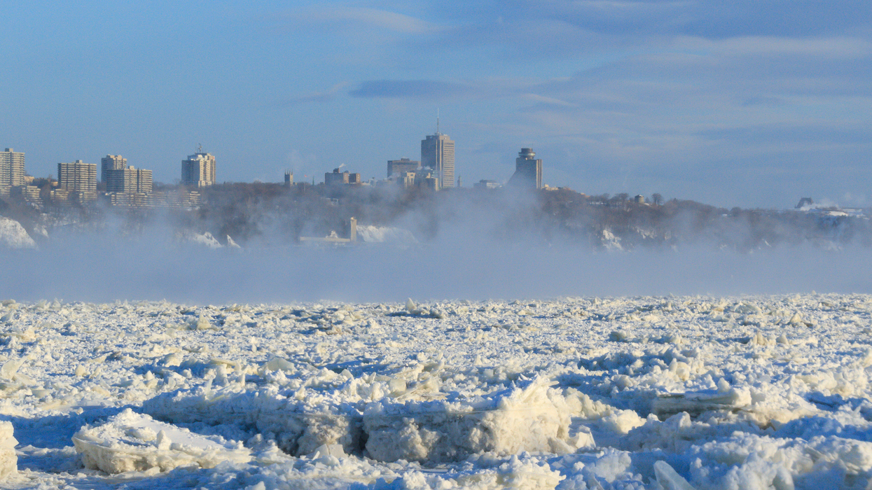 Une ville derrière un lac glacé au Québec.