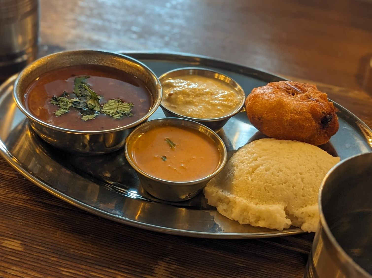 Vada, idly, sambar,  plain coconut chutney and red coconut chutney.