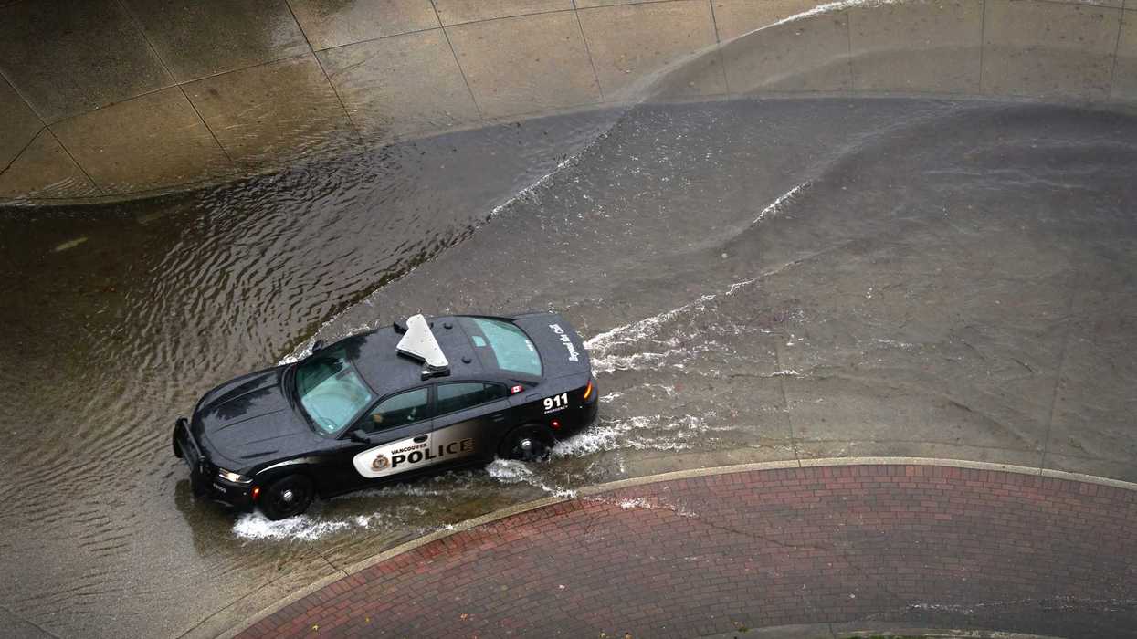 Vancouver police car drives through flooded street.