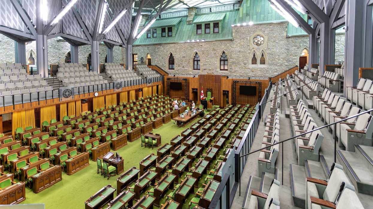 Vast green-carpeted House of Commons chamber.