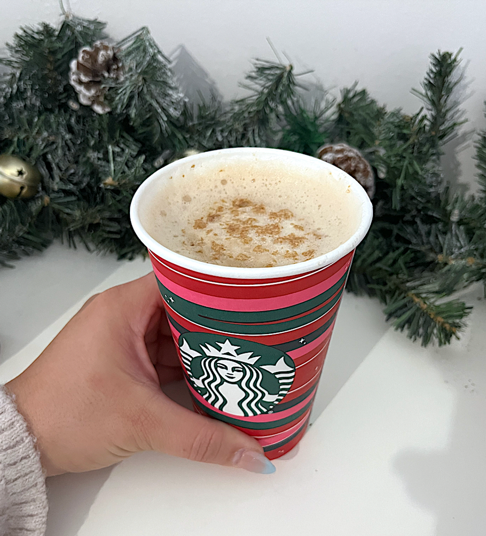 Verre des F\u00eates de Starbucks rouge, rose et vert qui comprend un caf\u00e9 couvert de mousse.