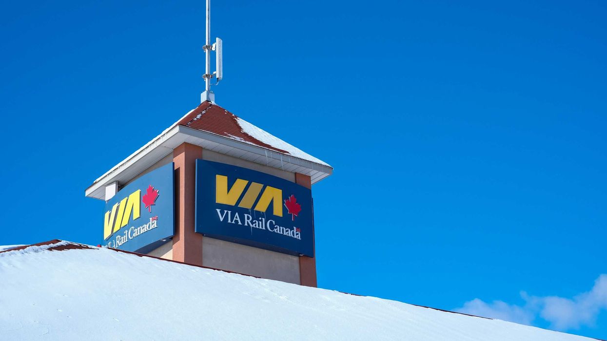 via rail sign on the snow covered roof of a train station in ontario
