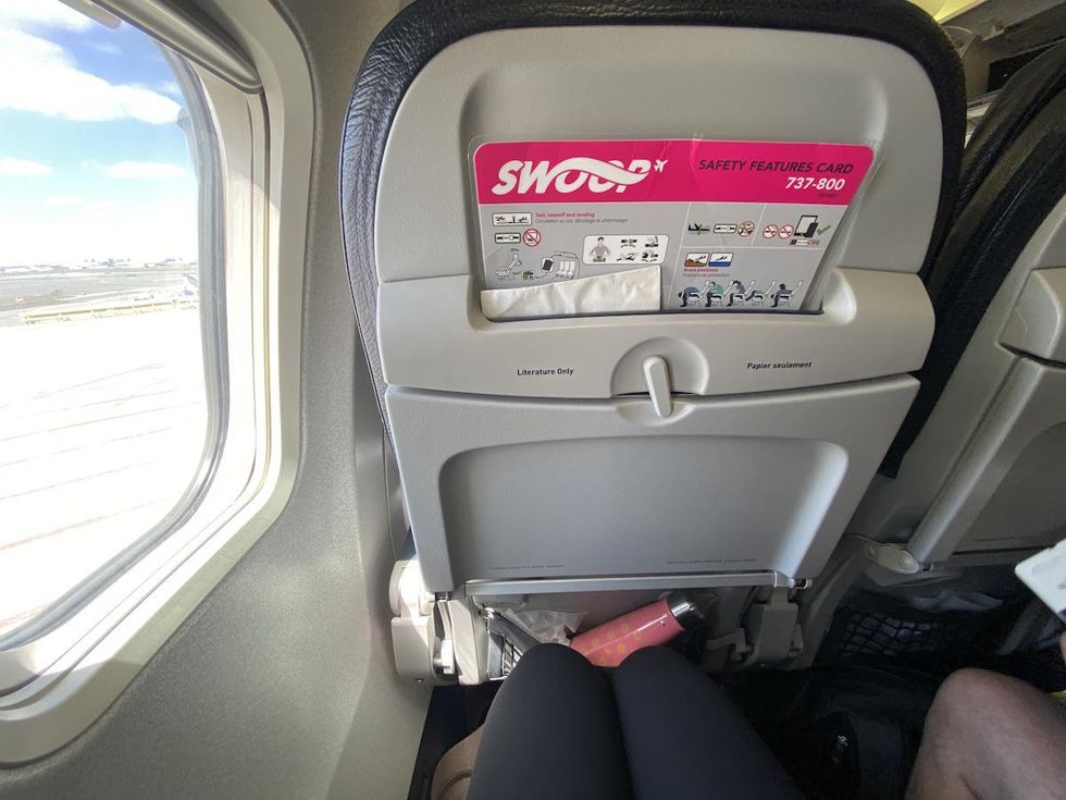 view of the seatback on a Swoop flight from Toronto to Cancun