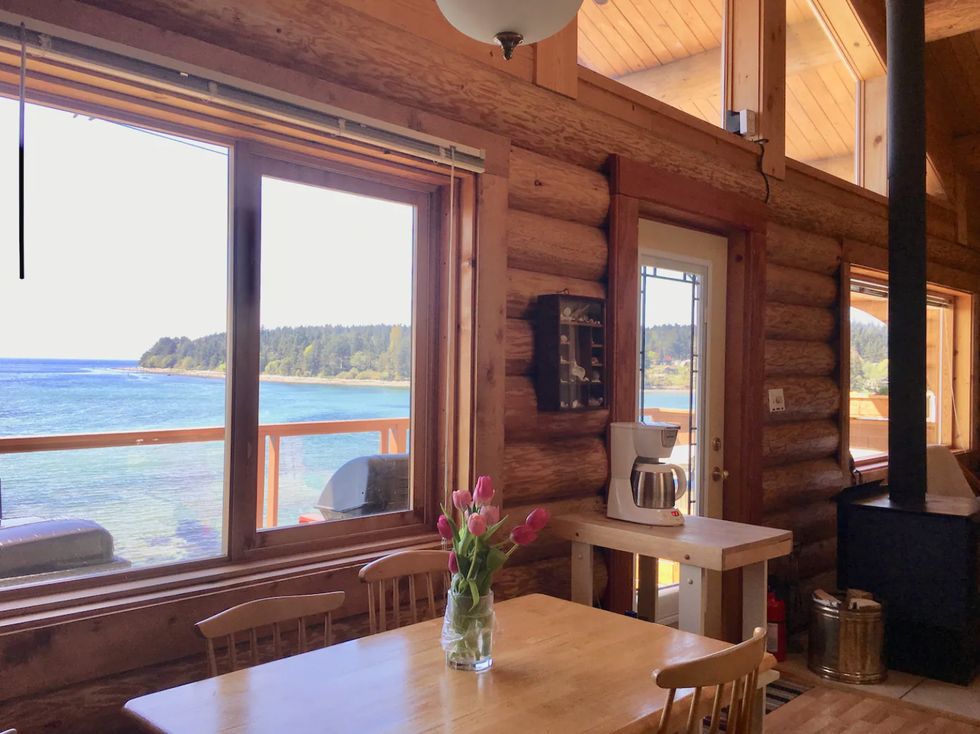 Views of the ocean from the kitchen table and living space of the wood cabin Airbnb.