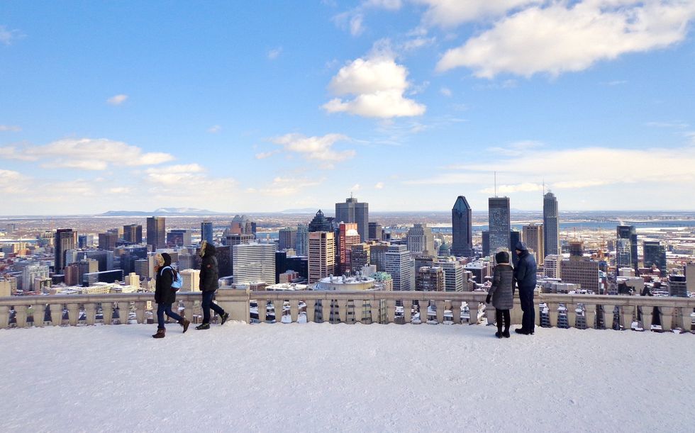 Visitors to Montreal's Kondiaronk Belvedere lookout take in views of the city in winter.