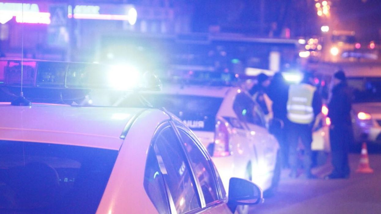 Voiture de police et policiers au loin.