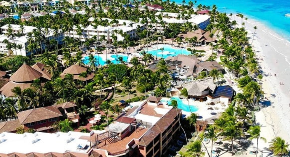 Vue a\u00e9rienne du VIK Hotel Arena Blanca en bord de mer \u00e0 Punta Cana avec piscines, palmiers et plage de sable blanc.