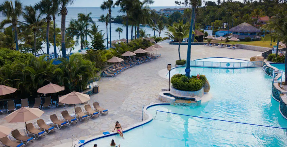 Vue a\u00e9rienne sur une piscine, les palmiers et la plage de l'h\u00f4tel Lifestyle Tropical Beach Resort and Spa \u00e0 Puerto Plata en R\u00e9publique dominicaine.