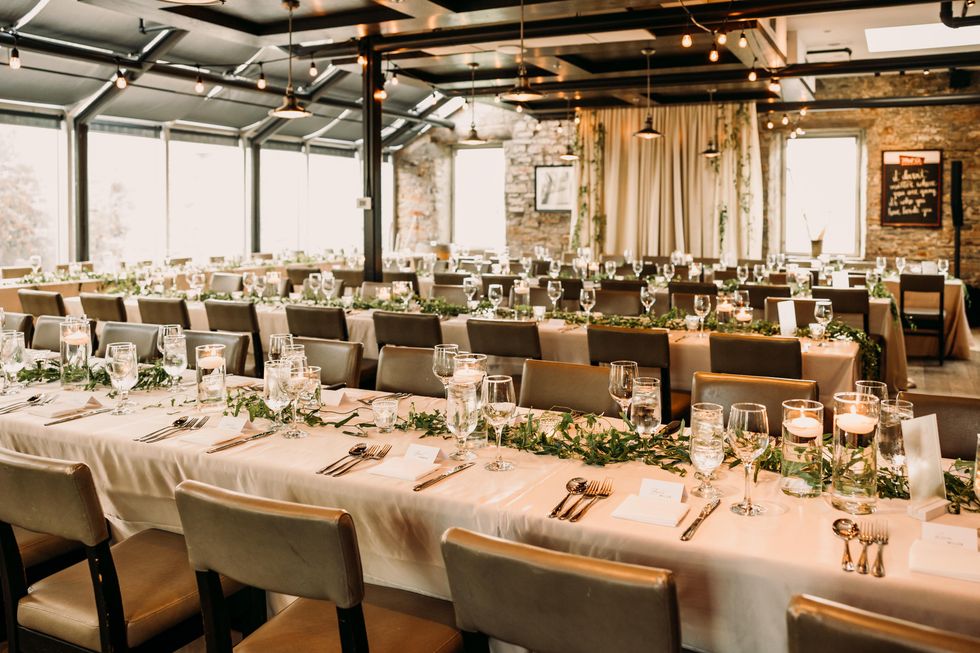 Wedding dinner set up by Frid Events at Mill Street Brew Pub with simple greenery and candles.