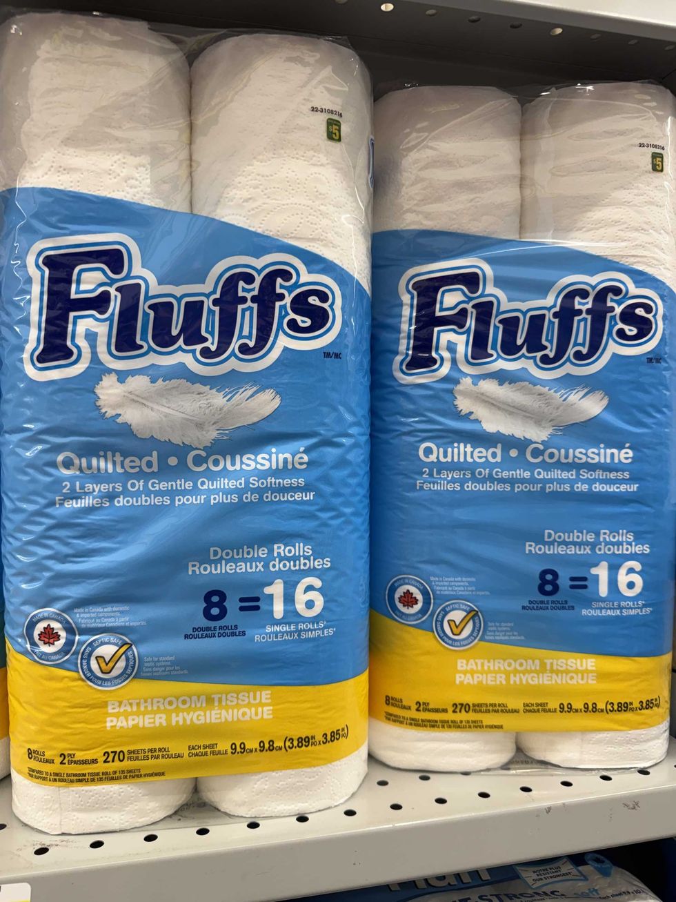 White and blue bags of toilet paper rolls with Fluffs quilted labels on the front.