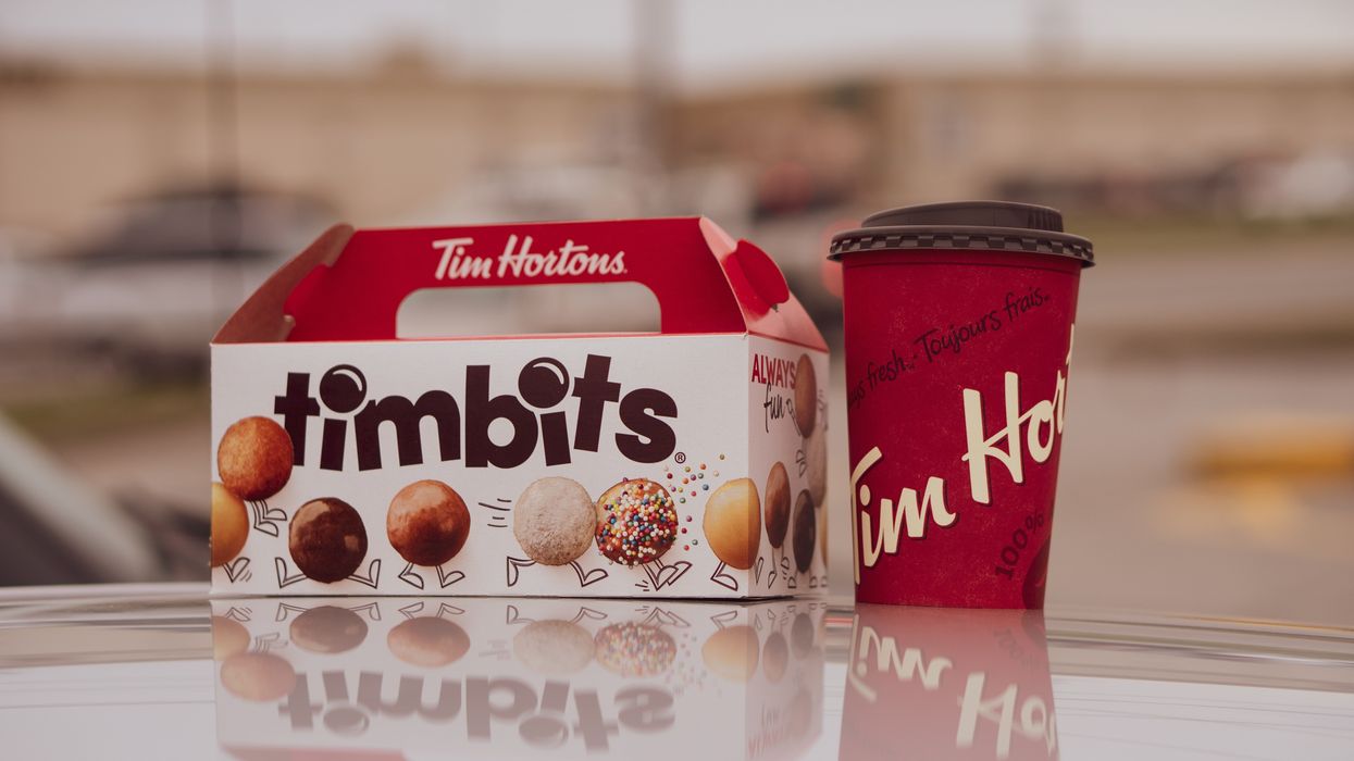 white and red box of timbits next to a red tim hortons coffee cup