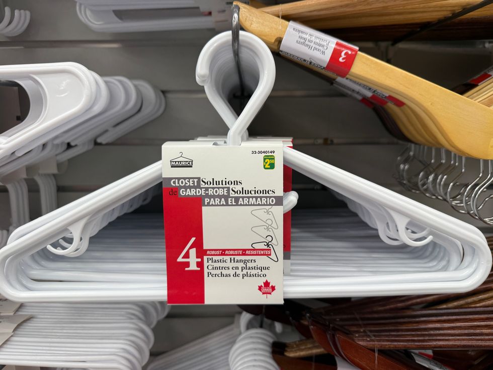 White clothing hangers on a store shelf.
