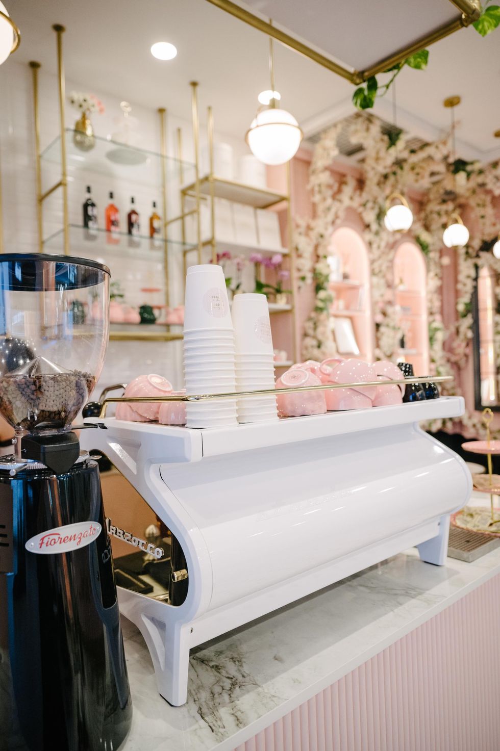 White coffee machine with pink mugs.