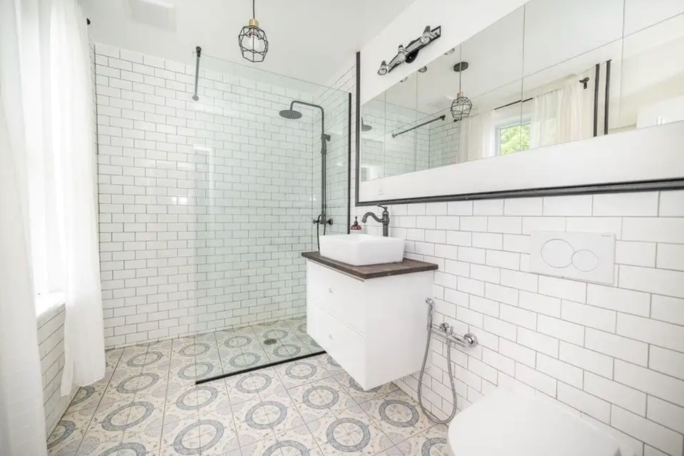 White tiled bathroom with a walk-in shower.