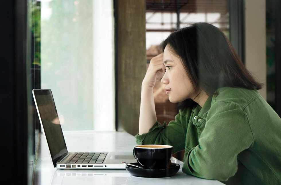 Woman in coffee shop looking at laptop
