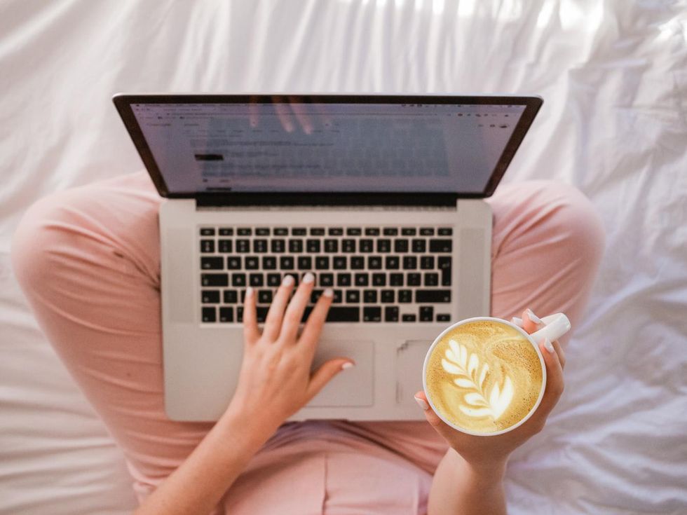 Woman on laptop holding coffee