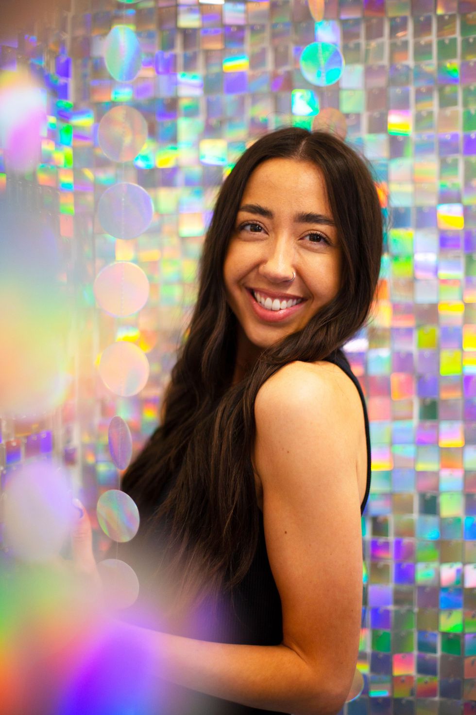 Woman posing with a glittery background.
