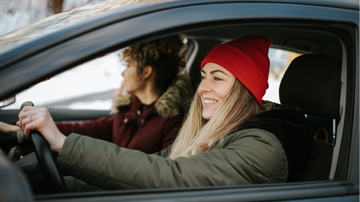 Woman smiling in car on a winter drive.
