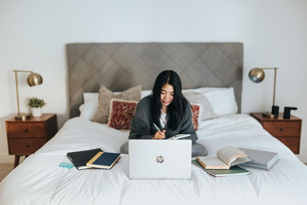 Woman writing in front of laptop
