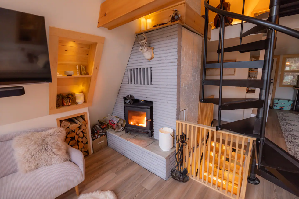Wood-burning fireplace and spiral staircase in the living room.