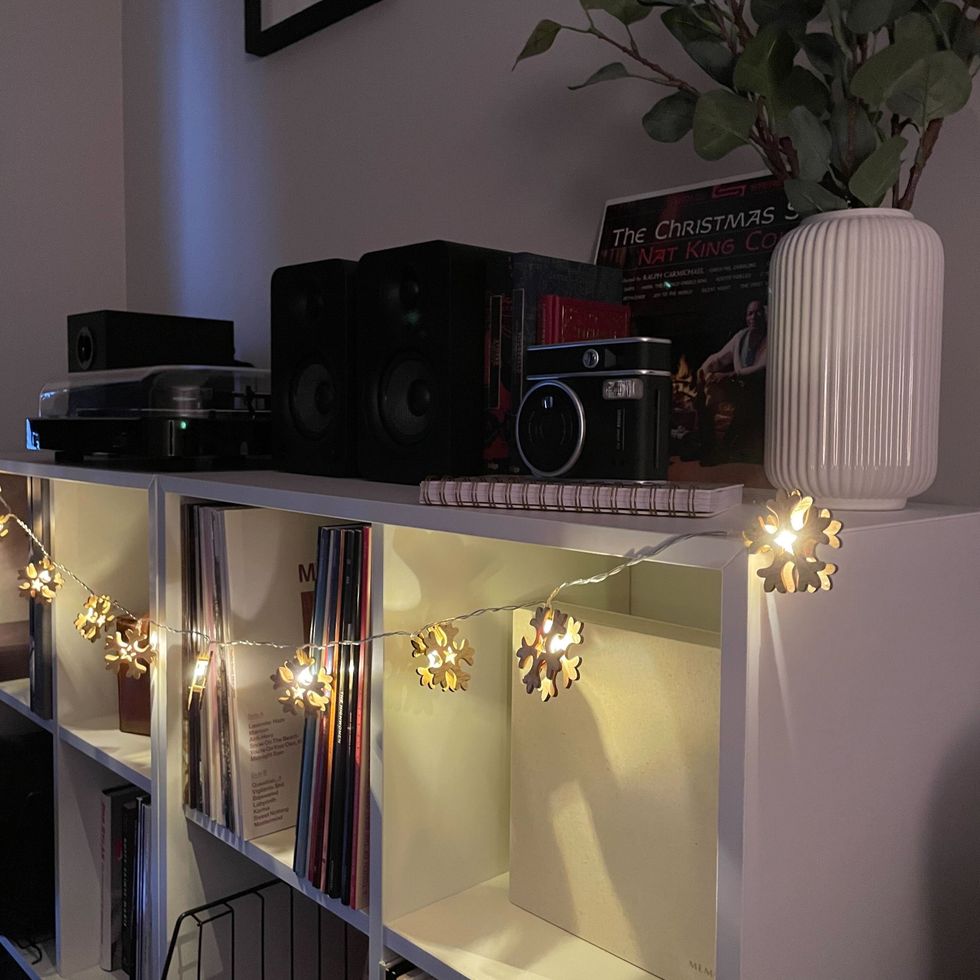 wooden snowflake led string lights from dollarama hanging on a white shelf with cubbies