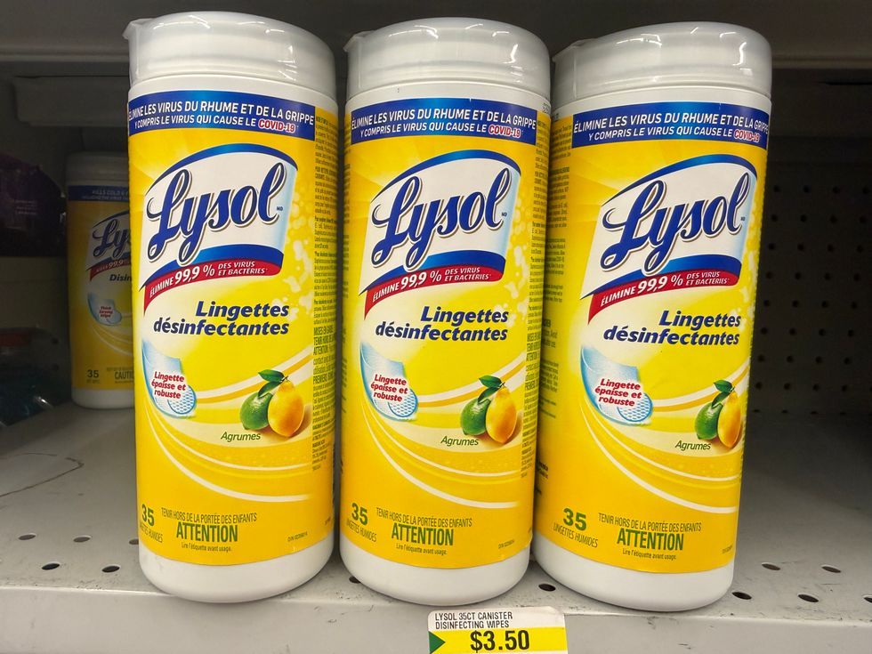 Yellow and white plastic tubes that say Lysol disinfecting wipes on a store shelf.